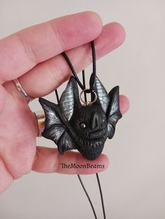 "Hand-painted polymer clay Black and Silver bat pendant necklace MADE TO ORDER PROCESSING TIME 1-2 WEEKS It will be created for you, just like the one in the pictures, please allow slight variations due to the handmade nature of the piece, which makes each bat unique :) The new version of my classic Chubby Bat pendant Made by me using Black polymer clay,with silver accents(wings and ears) With Hematite eyes. It is 2\" wide and 2\" tall the back is flat It comes with a black cotton cord 18\" with Painted Polymer Clay, Bat Pendant, Black Polymer Clay, Bat Jewelry, Kawaii Goth, Cute Bat, Polymer Clay Pendant, Halloween Jewelry, Pretty Gift