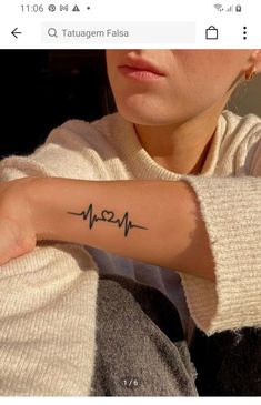 a woman with a heartbeat tattoo on her arm