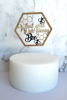 a cake topper that says, what will we honey be? on it in gold glitter