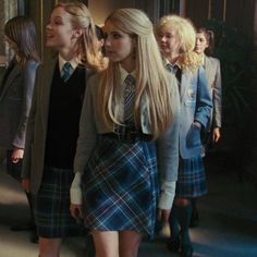 two girls in school uniforms are standing next to each other and one girl has long blonde hair