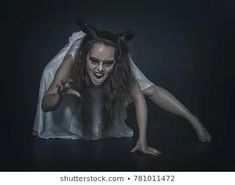 a woman dressed as a demon is posing for the camera