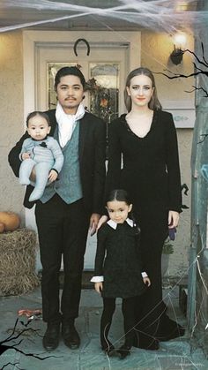 a family dressed up for halloween standing in front of their house