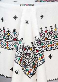 an embroidered table cloth with snowflakes on it