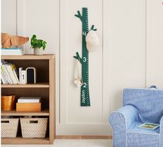 a blue chair sitting in front of a wooden growth chart