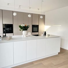 a modern kitchen with white cabinets and stainless steel counter tops, along with an island in the middle