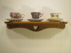 three teacups are sitting on a shelf next to each other with hearts in them