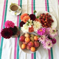 a table topped with plates filled with fruit and flowers