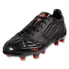 a pair of black soccer shoes with red soles