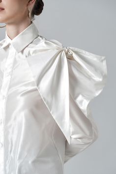 With a large size bowtie detail at the shoulder, the classic shirt now stands out like never before. High-quality silk material is selected to bring a moderate shine to the surface and created an impressive visual effect for the product. Note:*Processing time takes 7-10 working days (including 3-5 working days for manufacturing and NOT including shipping time)**Backorder Definition- The product is low in stock and in case the customer purchased successfully after out of stock, the order will nee Silk Tie Neck Blouse With Bow, Fitted Bow Tie Blouse For Party, Fitted Party Blouse With Bow Tie, Silk Party Blouse With Pleated Sleeves, Silk Blouse With Pleated Sleeves For Party, Fitted Elegant Blouse With Bow, Elegant Fitted Blouse With Bow, Feminine Party Blouse With Bow, Elegant Evening Top With Bow