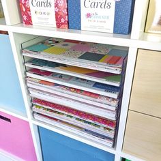 several books are stacked on top of each other in a bookcase with drawers underneath