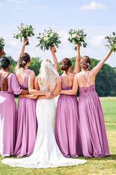 the bridesmaids are holding their bouquets high in the air