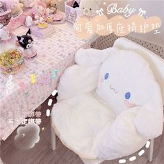 a white teddy bear sitting in a chair next to a table with other stuffed animals on it