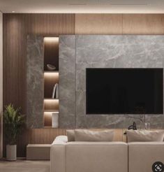 a modern living room with white couches and a flat screen tv mounted on the wall