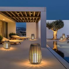 an outdoor area with lights and chairs on the ground next to a large swimming pool