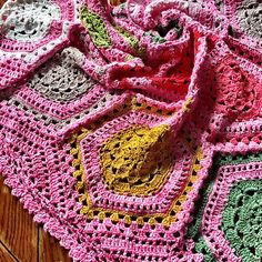 a crocheted blanket on top of a wooden table