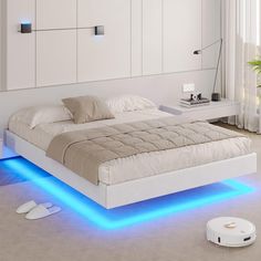 a white bed with blue lights on the bottom and headboard is shown in this modern bedroom