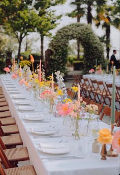 a long table is set with flowers and candles