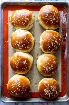 sesame buns on a baking sheet ready to be baked in the oven for dinner