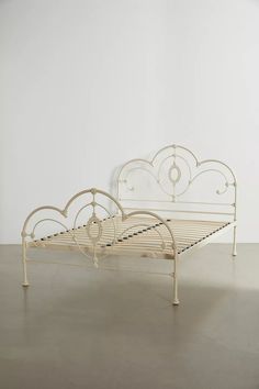 a white metal bed frame sitting on top of a floor