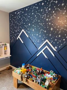 a child's room with mountains painted on the wall and stars in the sky