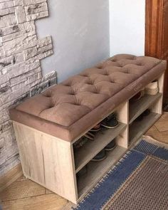 a brown bench with shoes on it in front of a brick wall and blue rug