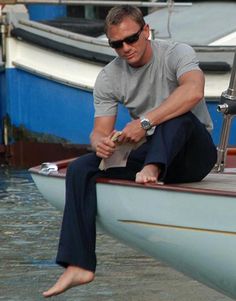 a man sitting on top of a boat in the water