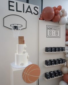 a birthday cake is displayed in front of balloons and basketballs on display at an event