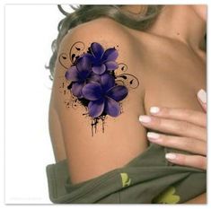 a woman's shoulder with purple flowers painted on the back of her arm and chest