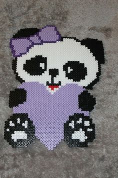 a panda bear with a purple dress on it's chest sitting on the floor