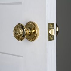 an open door with a golden handle and knobs on it's front door