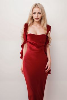 a woman in a red dress posing for the camera with her hands on her hips