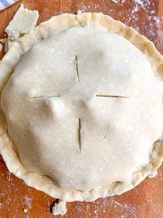 an uncooked pie sitting on top of a wooden table