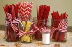 red and white striped straws in mason jars with utensils tied around them