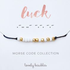 a close up of a bracelet on a card with the words luck and morse code collection