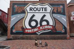 two dogs are standing in front of a large mural on the side of a building