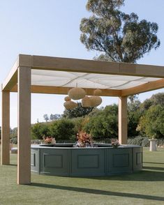 an outdoor bar with lights hanging from the ceiling and potted plants on the counter