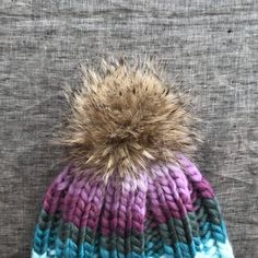 "D E T A I L S + A warm & soft hand knitted, oversized beanie with faux fur pompom + The beanie color is a geode - purple, turquoise, greens + Made with a soft blend of wool &acrylic. + Adult size + Hand wash, dry flat + READY TO SHIP! M E A S U R E M E N T S Adult - 23\" / 58.5cm >> Check shop announcement for current turn around time. >> Please let me know before purchasing if you need an item in a certain time frame. >> SHIPPING: First Class, Priority Mail, & Pri Purple Winter Hat For Cold Weather, Purple Warm Hats For Cold Weather, Warm Purple Hats For Cold Weather, Cold Weather Beanie With Pom Poms, Winter Purple Knitted Hat, Purple Crochet Winter Hat, Warm Purple Beanie For Winter, Warm Purple Winter Beanie, Purple Yarn Beanie For Winter