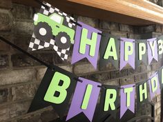 a happy birthday banner hanging on a brick wall