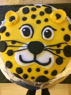 a cake decorated to look like a leopard's face with black dots on it