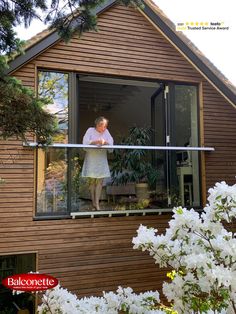 a woman standing in the window of a house