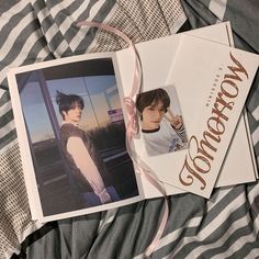 an open photo book with the cover pulled down and ribbon tied around it on top of a bed