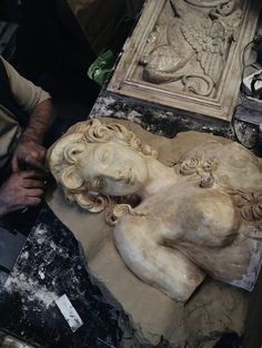 a man is working on a statue in the process of being carved and sanded