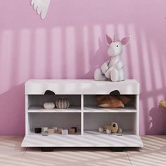 a white toy rabbit sitting on top of a book shelf next to a pink wall