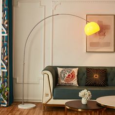 a living room with a couch, coffee table and lamp on the wall next to it