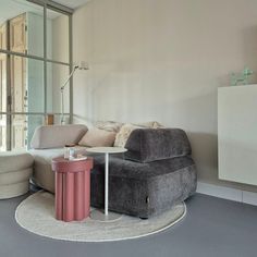 a living room filled with furniture and a large mirror on the wall above it's windows