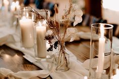 a table with candles, flowers and napkins on it is shown in this image