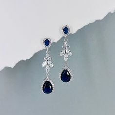 Material -  ~ Top quality sapphire colour teardrop cubic zirconia components ~ 26 x 11mm Austrian floral-shaped crystal connector  ~ Finished with rhodium-plated earring post ~ Nickel and lead free ~ Matching necklace available for purchase upon request Size -  ~ Earrings is 2.5 inches / 6.35cm Matching Bracelet Options: ~ https://www.etsy.com/listing/1750341777 ~ https://www.etsy.com/listing/1751671833 Back to our shop for more jewelry and gift idea: dcjoaillerie.etsy.com Sapphire Dangle Crystal Earrings For Formal Occasions, Sapphire Crystal Dangle Earrings For Formal Events, Sapphire Crystal Dangle Earrings For Formal Occasions, Blue Elegant Teardrop Pendant Earrings, Blue Elegant Teardrop Earrings, Elegant Blue Teardrop Earrings, Blue Pear-shaped Teardrop Earrings, Elegant Blue Teardrop Pendant Earrings, Blue Drop Bridal Earrings For Formal Events