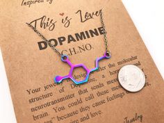 this is love necklace with the word dopamino on it and a dime