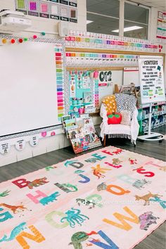 an area rug with letters and animals on it in a school room, surrounded by bookshelves