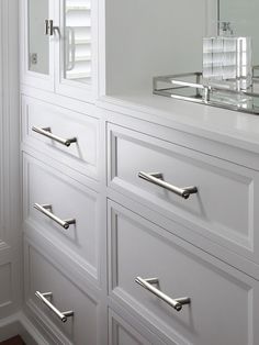 a white dresser with drawers and a mirror